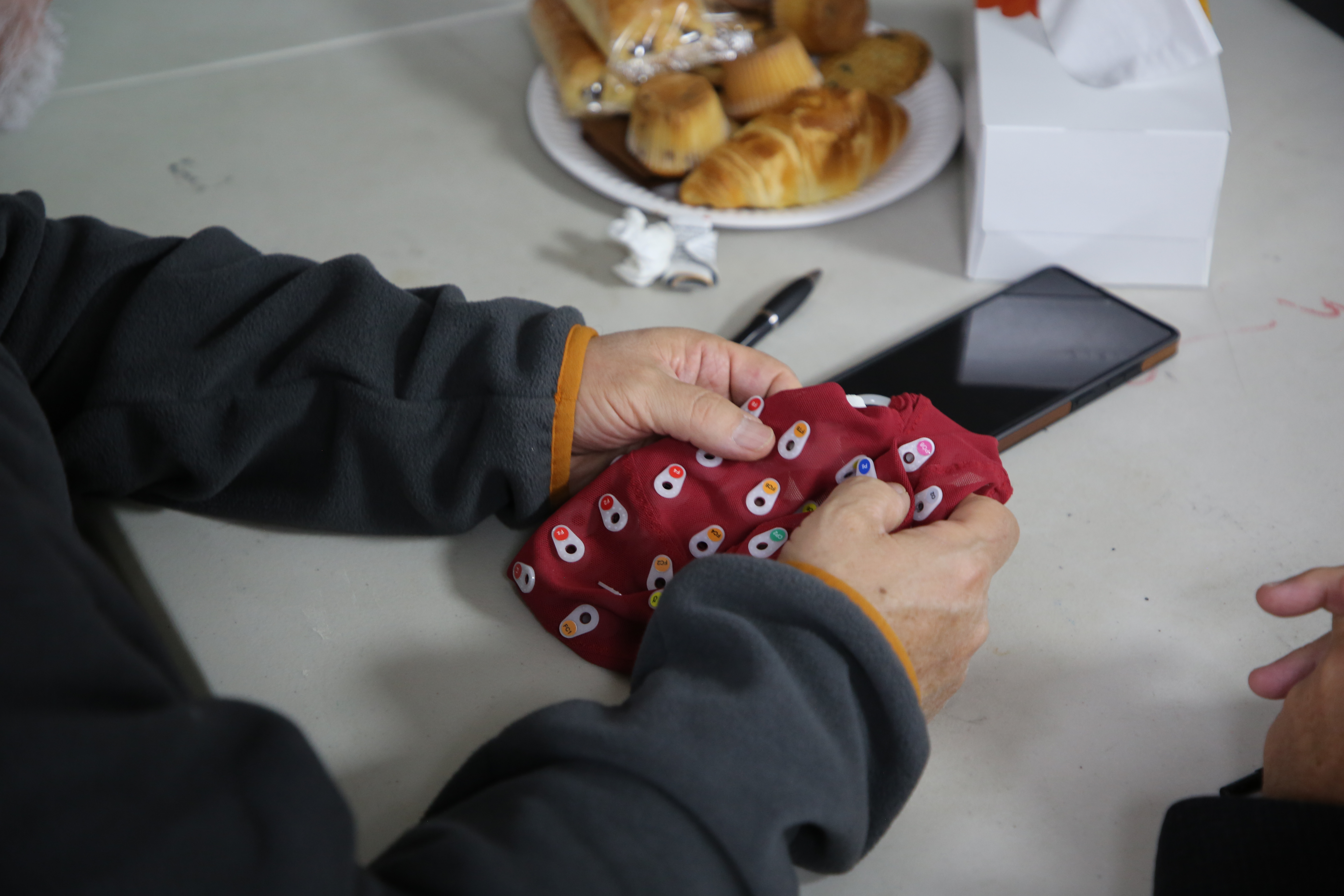 A community member holding a high density EEG cap brought for demonstration